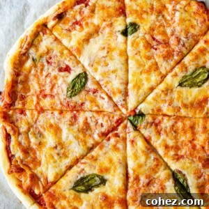 Top-down view of puff pastry pizza margherita on a baking tray, golden brown and cheesy