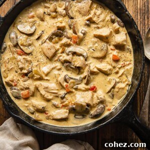 A top-down view of Turkey a la King in a pan, featuring tender turkey pieces, colorful bell peppers, and mushrooms in a creamy sauce.