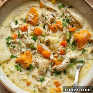 A top-down shot of a rich, creamy leftover turkey chowder served in a small bowl, garnished with fresh herbs, evoking warmth and comfort.