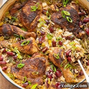Top down shot of Jamaican chicken with rice and peas in a pan with a serving spoon