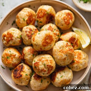 A generously sized bowl filled with perfectly cooked, golden-brown chicken feta meatballs, ready for dipping.