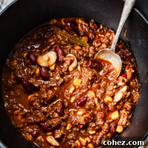 Top down view of a rich, robust Texas-style chili in a rustic pot, ready to be served.
