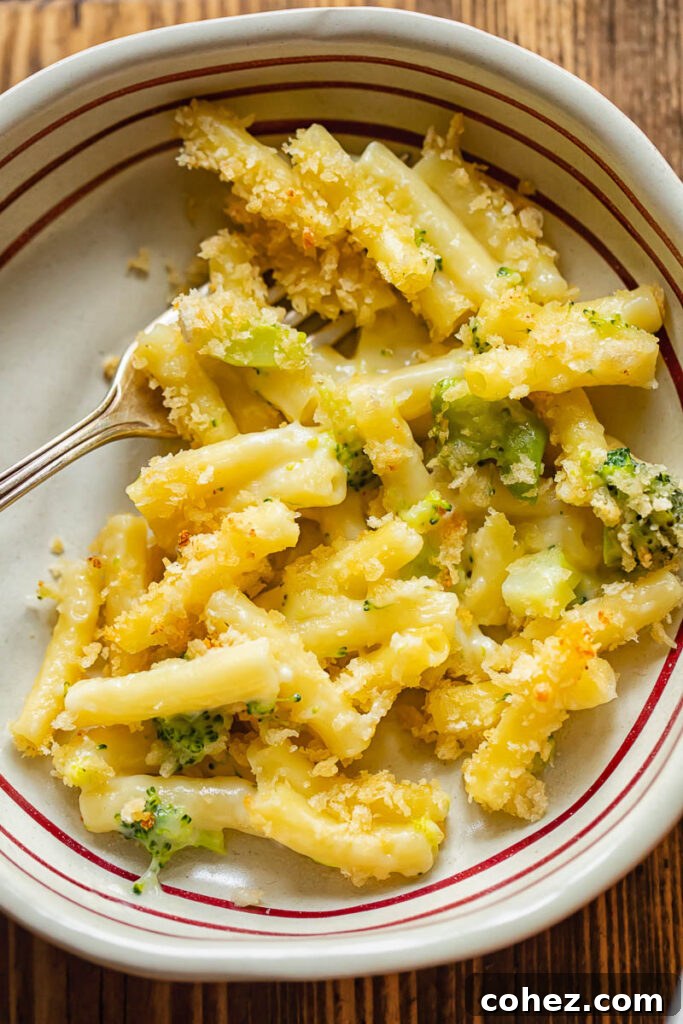 Golden Broccoli Mac and Cheese Bake 3 A serving of baked broccoli mac and cheese in a rustic bowl, garnished with fresh parsley.