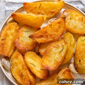 Top-down view of perfectly golden roast potatoes, crispy and delicious, arranged on a white plate.