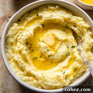 Top-down view of velvety Instant Pot mashed potatoes, generously drizzled with melted butter and fresh chopped parsley.