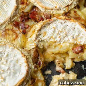 Top-down shot of a rich and bubbling Tartiflette in a rustic cast iron pan, ready to be served.