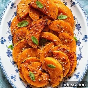 roasted butternut squash slices on a plate with basil garnish