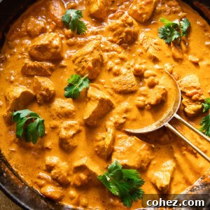 Top down view of aromatic Chicken Tikka Masala simmering in a pan, vibrant and enticing.
