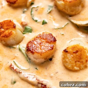 A close-up shot of perfectly seared scallops bathing in a creamy, rich 'Marry Me' sauce, garnished with fresh herbs.