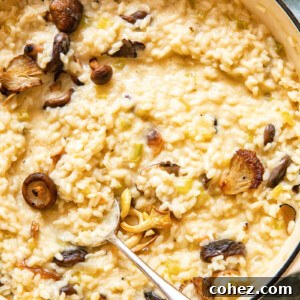 A close-up shot of a bowl of creamy Truffle Risotto, garnished with fresh herbs and a spoon resting in it, highlighting its rich texture.