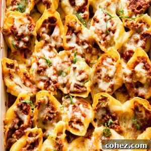 Close-up of beef-stuffed giant pasta shells, beautifully topped with melted mozzarella and fresh herbs.