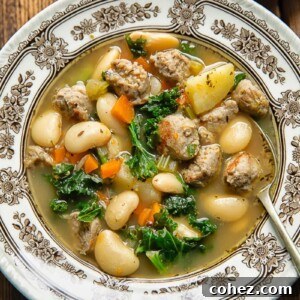 Top down shot of a spoon and a bowl of soup with sausage and white beans