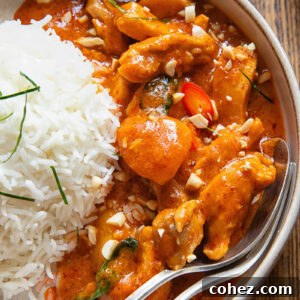 close view of curry in a bowl next to a ball of rice, with a spoon and fork