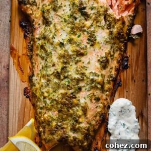 A large fillet of cedar plank salmon on a wooden cutting board, ready to be served