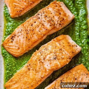 Pan-seared salmon fillets topped with a vibrant green basil pesto sauce