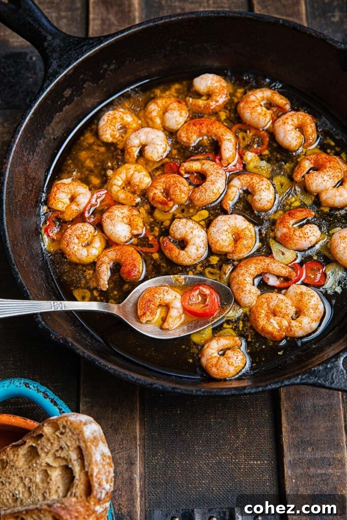 Top down shot of gambas pil pil i a pan with a serving spoon