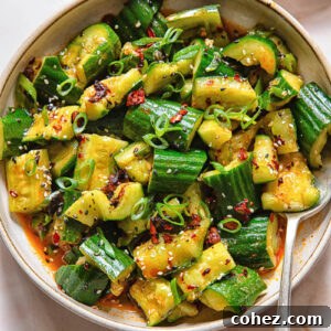 Top down shot of smashed cucumber salad in a bowl with a spoon
