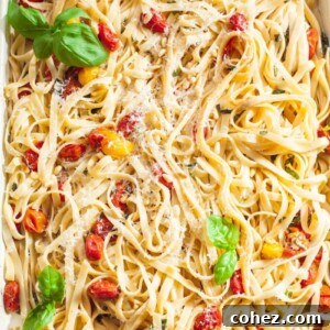 Tagliatelle tossed with roasted cherry tomato and basil sauce on a rectangular pan
