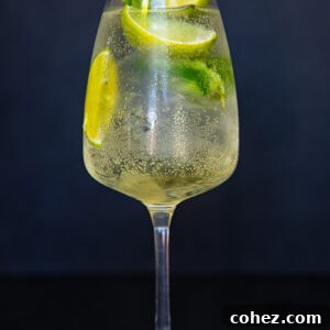 vertical photo of white wine glass with limoncello spritz