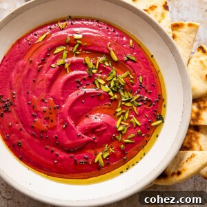 Bowl of beetroot borani with seeds, mint and flatbread