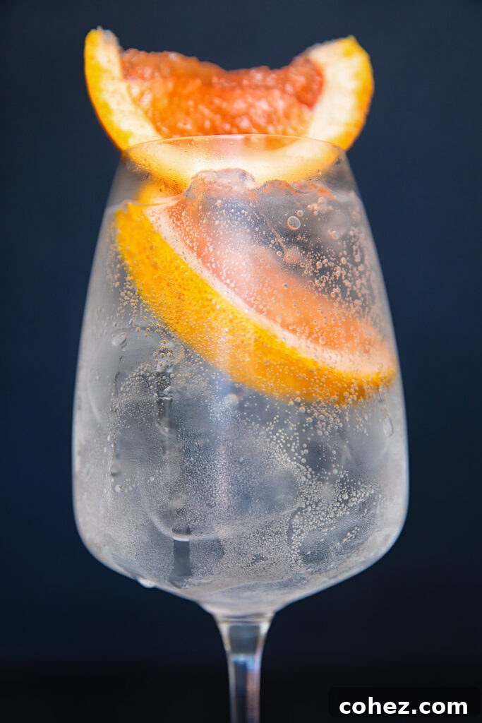 Close up of a wine glass with the spritz with two prominent slices of grapefruit on top.