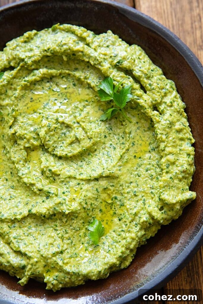 Close up image of green sauce on a dark plate and background.