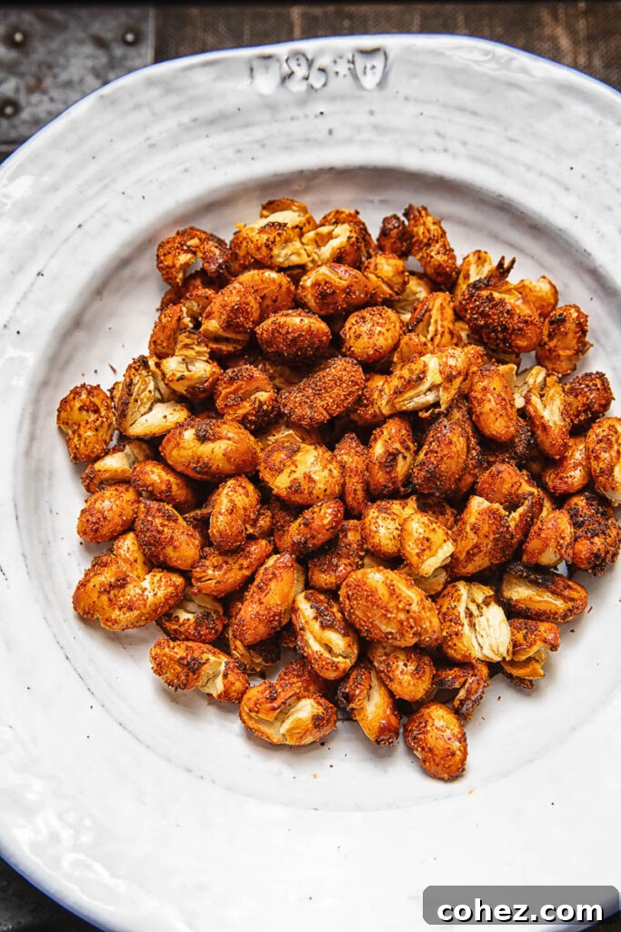 A pile of spiced butter beans on a white plate against a wood background.