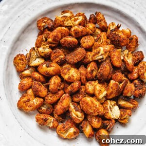 A pile of spiced butter beans on a white plate against a wood background.