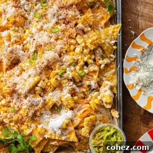 Close up of a corner of a baking sheet with nachos against a wooden background.